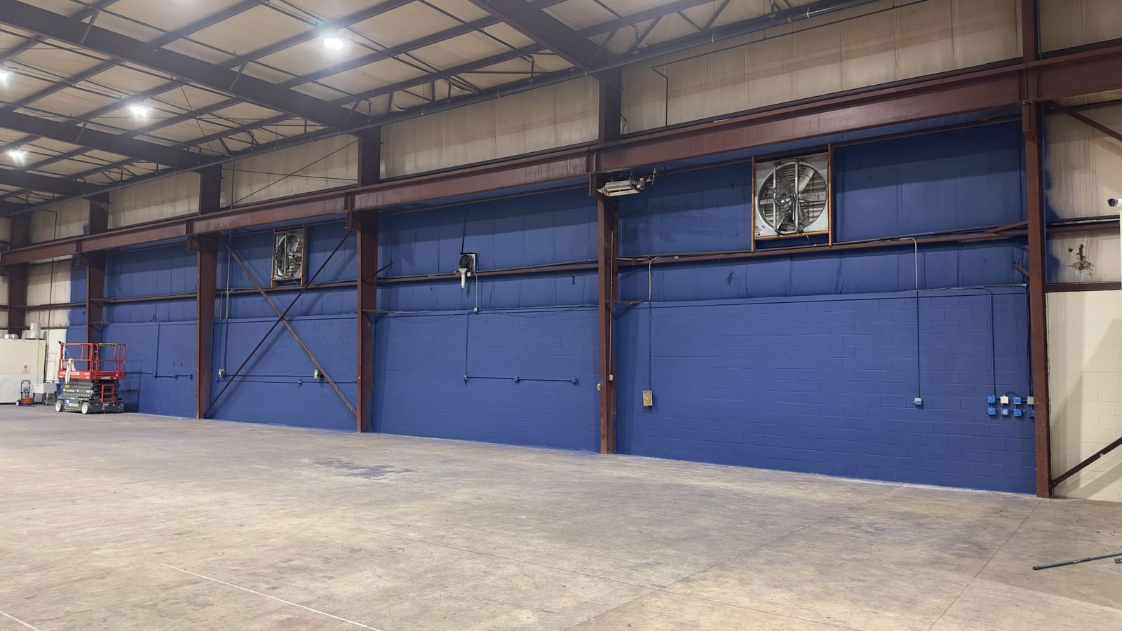 Crew painting the court walls blue inside the facility