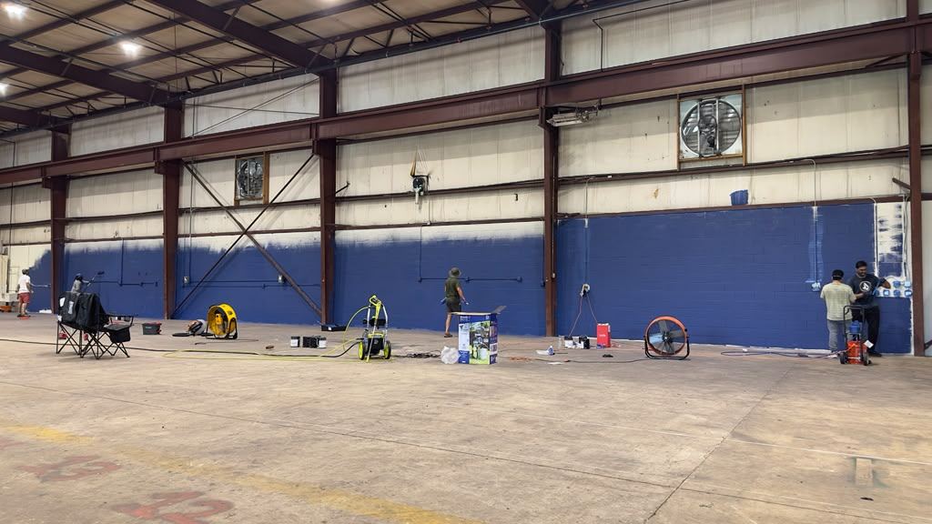 Interior of the Philadelphia Badminton facility showing the open warehouse space with painted court walls
